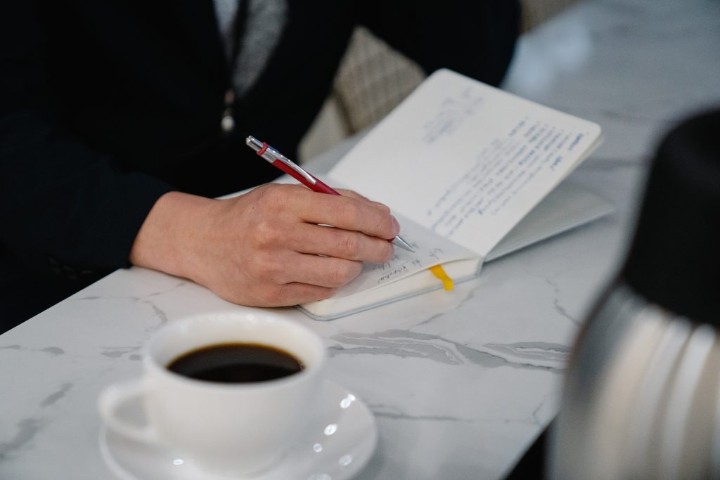 man writing in personalised notebook